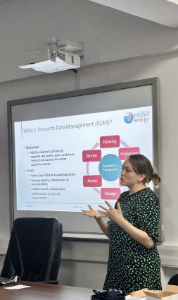 Person standing in front of a beamed presentation with both hands raised